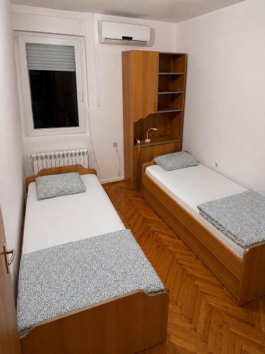two beds in a small room with a window at Apartman City With 3 Bedooms And Free Parking in Negotin