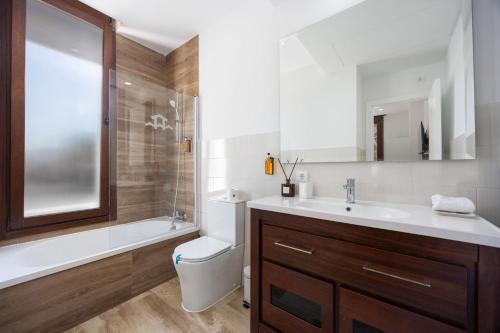 a bathroom with a sink and a toilet and a tub at Fely Sea Villa in Novo Sancti Petri