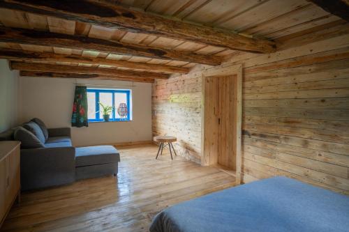 ein Wohnzimmer mit Holzwänden und einem Sofa in der Unterkunft Camping OR in Bucureşci
