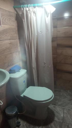 a bathroom with a toilet and a shower curtain at Luna Llena in Suesca