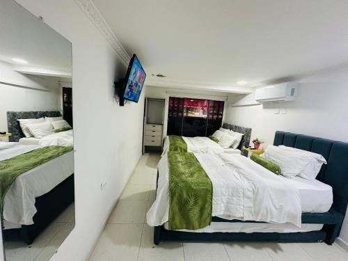 ein Schlafzimmer mit zwei Betten und einem Fernseher an der Wand in der Unterkunft Hotel plata inn in Villavicencio