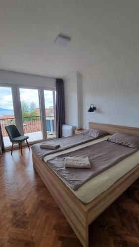 a large bed in a room with a large window at Lukanov Apartments - Lake view in Ohrid
