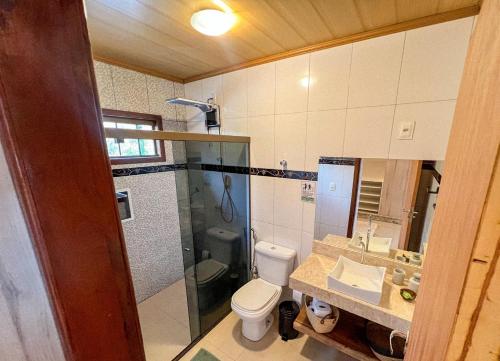 a bathroom with a shower and a toilet and a sink at Jungla House Hostel in Alto Paraíso de Goiás