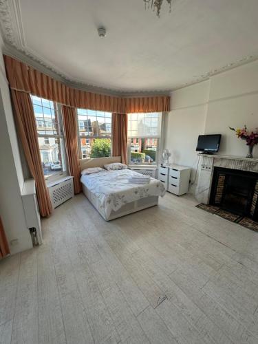 a large bedroom with a bed and a fireplace at Catherine Lodge Finchley in Whetstone