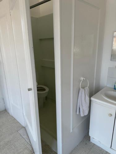 a white bathroom with a toilet and a sink at Catherine Lodge Finchley in Whetstone