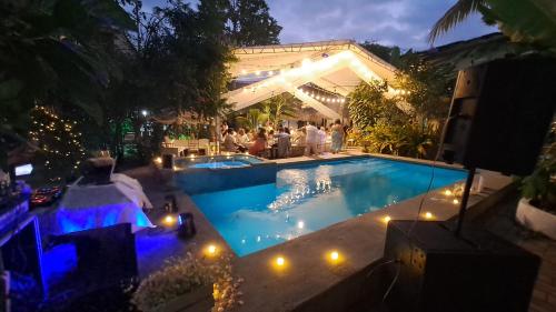 a group of people standing around a swimming pool at night at Hotel Sumpa in Montañita
