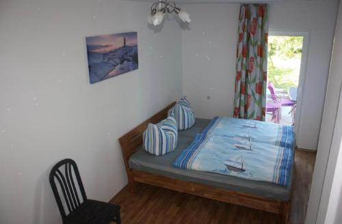 a small bedroom with a bed and a chair at zum Dünengras in Saal