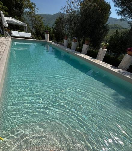 a large swimming pool with blue water at Casa Bianca in Vaiano