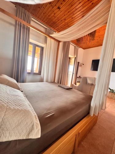 a bedroom with a large bed with a wooden ceiling at Jasmine Stoupa in Stoupa