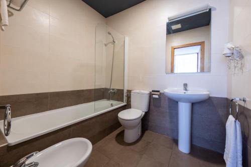 a bathroom with a sink and a toilet and a bath tub at Apolo Suites Rentalmar in Salou