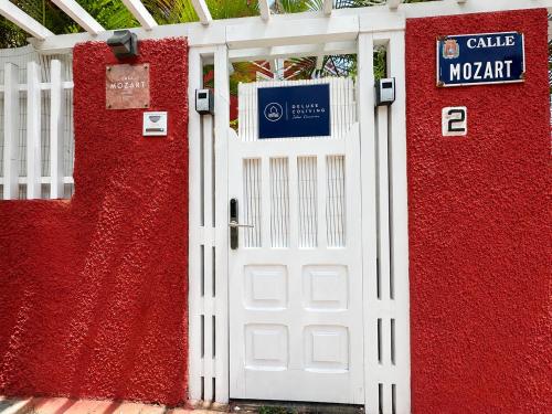 a white door in front of a red wall at Deluxe Coliving Islas Canarias in Las Palmas de Gran Canaria