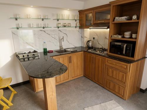 a kitchen with wooden cabinets and a granite counter top at SSR Wasana in Sita Eliya
