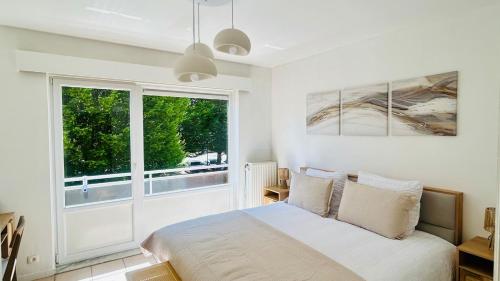 a bedroom with a bed and a large window at Brussels Expo & Atomium Prestige Suites in Grimbergen