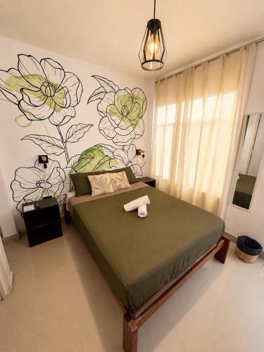 a bedroom with a bed with a flower mural on the wall at Hostel Killamoon Centro in Paracas