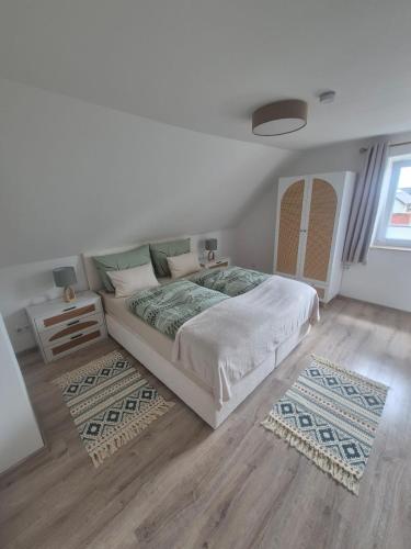 a white bedroom with a bed and a table at Detmolder Perle 2 Charmante Dachgesschoswohnung im Altbau in Detmold