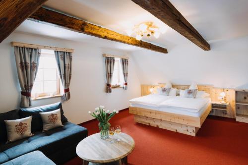 a bedroom with a bed and a couch and a table at Ferienhaus Zirbenliebe Altenberg in Kurort Altenberg