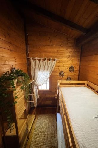 a bedroom in a log cabin with a window at Etna Essence Chalet in Trecastagni