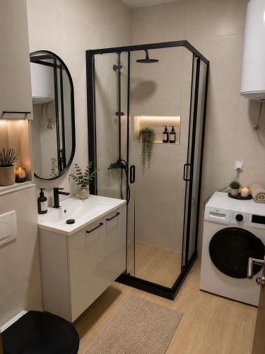 a bathroom with a shower and a sink and a washing machine at Adriatic Escape in Radanovići