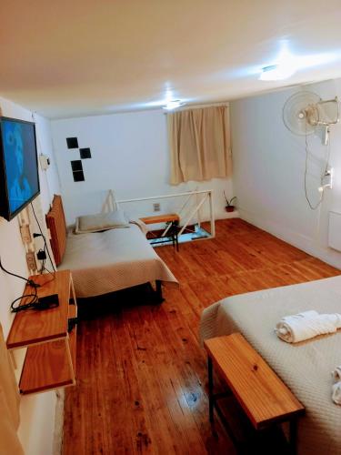 a room with two beds and a wooden floor at Mi casa, Su casa in Salta