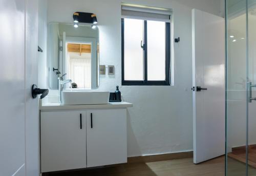 a white bathroom with a sink and a mirror at Solaris Villa in Las Terrenas
