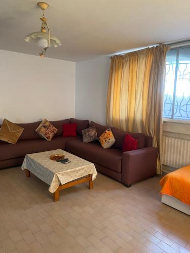 a living room with a brown couch and a table at Comme chez moi in El Harhoura