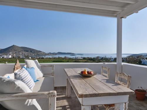 a porch with a wooden table and a couch at Two Bedroom Cycladic House With Sea View in Kampos Paros