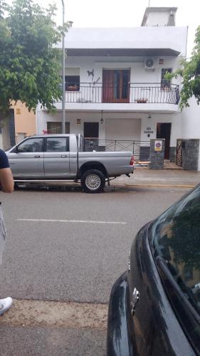 a truck parked in a parking lot in front of a house at Habitaciones Yanet in La Granada