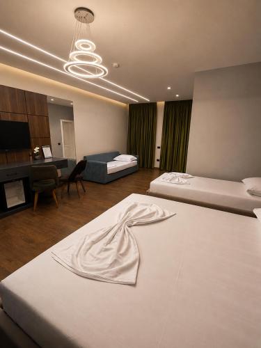 ein Schlafzimmer mit zwei Betten und ein Wohnzimmer in der Unterkunft Hotel Muja in Rinas