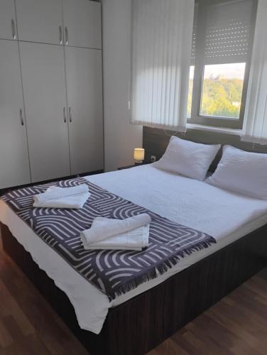 a bedroom with a bed with two towels on it at STADIUM 1 Apartments Sandanski in Sandanski