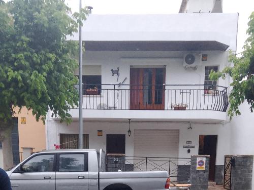 a truck parked in front of a white house at Habitaciones Yanet in La Granada