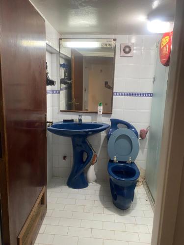 a bathroom with a blue toilet and a sink at Comme chez moi in El Harhoura