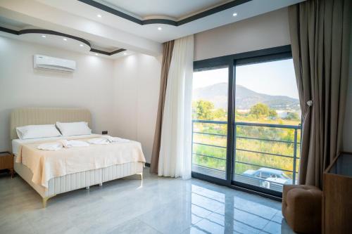 a bedroom with a bed and a large window at Villamona Dalaman in Bezkesen