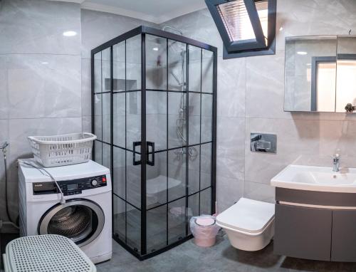a bathroom with a washing machine and a sink at Villamona Dalaman in Bezkesen