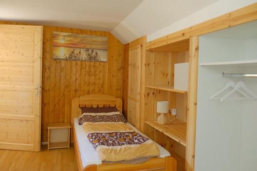 a bedroom with a bed in a wooden room at Árnyas Tölgy in Kismaros