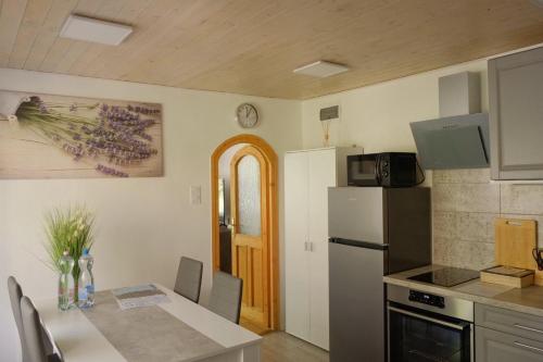 a kitchen with a table and a refrigerator at Árnyas Tölgy in Kismaros