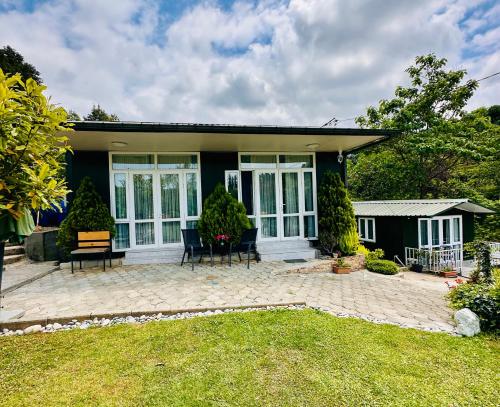 a house with a patio with chairs in the yard at Krupitskiy House in Chakvi