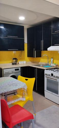 a kitchen with a table and a yellow chair at kvartira in Kutaisi