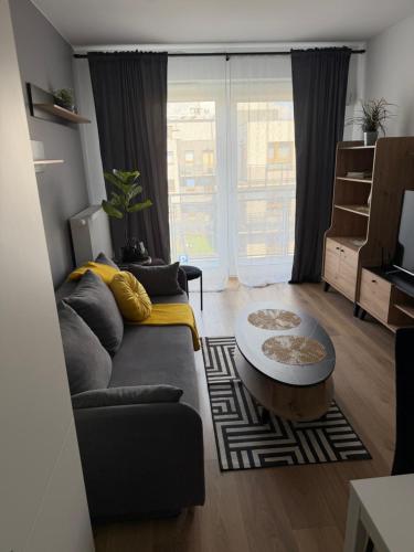 a living room with a couch and a coffee table at Apartament Grey 2 pokojowy z balkonem w Warszawie z parkingiem podziemnym in Warsaw