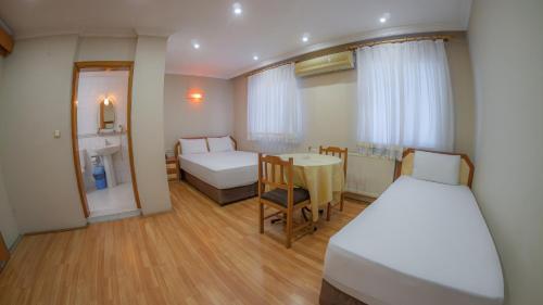 ein Zimmer mit zwei Betten, einem Tisch und einem Bett in der Unterkunft Hotel Flash in Artvin