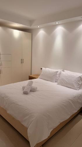 a large white bed with white sheets and pillows at סוויטת לה פלמורה in Eilat