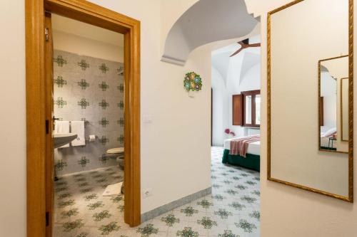 a bathroom with a mirror and a room with a bed at Villa Le Pagine Bianche in Lacco Ameno
