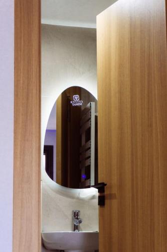 a bathroom with a sink and a mirror at Hostel Tamim in Fort de lʼEau