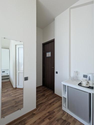 a kitchen with white walls and a wooden floor at Hotel Captain in Gonio