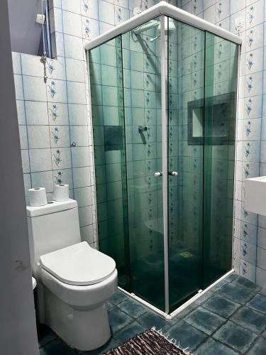 a bathroom with a toilet and a glass shower at Pousada Caravela in Arraial do Cabo
