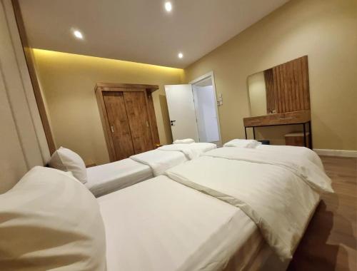 a room with three beds and a mirror at مساكن للشقق الفندقيه in Riyadh