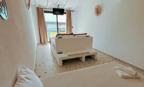 a white bedroom with a bed and a table at Thanos Hotel in Muğla