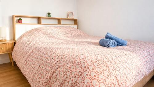 a bedroom with a bed with a blanket and a night stand at L'Écrin Bois & Lin in Nevers