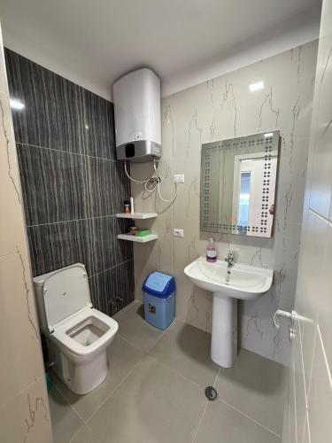 a bathroom with a toilet and a sink at Leonard's Shengjin Apartments in Lezhë