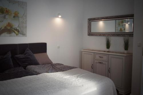 ein Schlafzimmer mit einem Bett und einem Spiegel an der Wand in der Unterkunft Schlossperle in Klütz