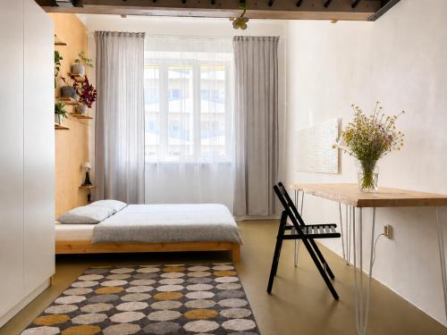a bedroom with a bed and a desk and a window at Like at home Brno - celý byt in Komárov